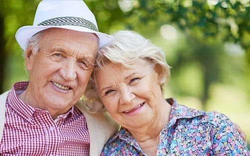 smiling elderly couple sitting next to each other